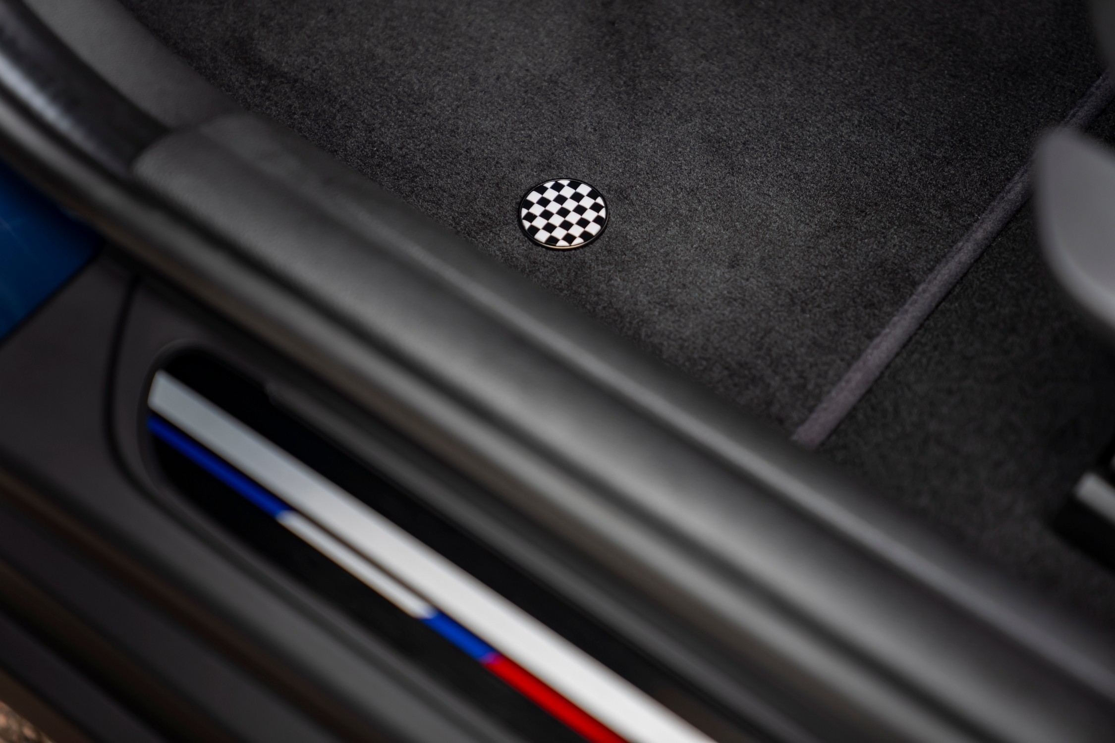 Detalhe do tapete do MINI Cooper Oxford Edition, com símbolo circular em padrão xadrez